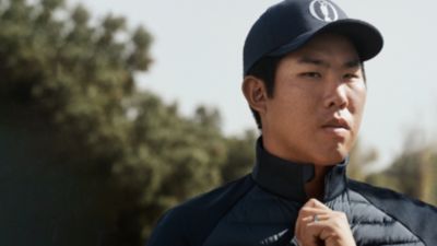 Byeong-Hun An wearing blue pants, a brown belt and a blue polo shirt by BOSS Green