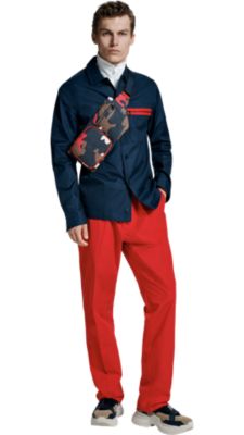 Man in blue shirt, orange trousers, and camo bag by BOSS menswear