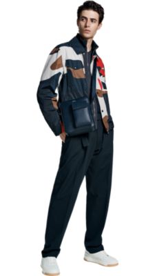 Man in camoflauge jacket and blue trousers by BOSS menswear