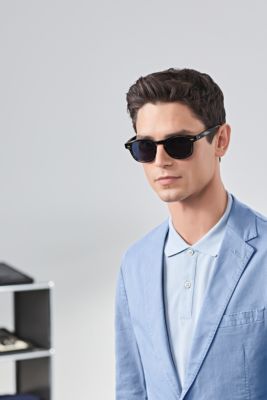 M&auml;nnliches Model mit blauem Anzug und schwarzer Sonnenbrille von BOSS 