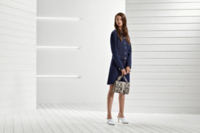 Woman is wearing denim jacket paired with denim skirt form BOSS womenswear