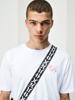 Male model wearing a white T-shirt and a black bag by HUGO