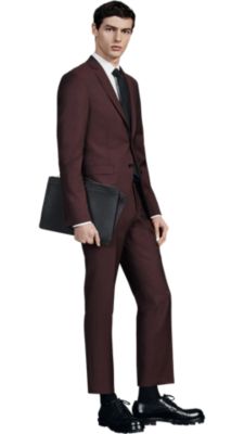 Man is  wearing a dark red BOSS suit and black BOSS neckwear with black BOSS shoes and BOSS leather bag