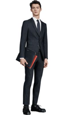 Men is wearing a BOSS suit over a white BOSS shirt and BOSS neckwear with BOSS shoes and BOSS leather bag 
