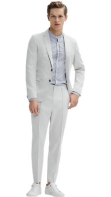 Man wearing a natural jacket, white shirt, natural trousers and white shoes by BOSS