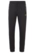 Half-cuffed jogging trousers with curved logo, Black