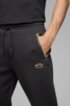 Half-cuffed jogging trousers with curved logo, Black