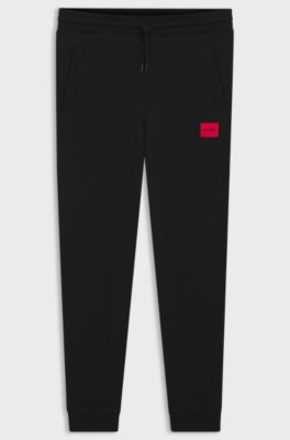 Cotton-terry tracksuit bottoms with red logo label, Black