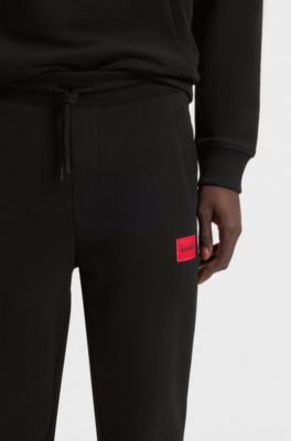 Cotton-terry tracksuit bottoms with red logo label, Black