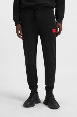 Cotton-terry tracksuit bottoms with red logo label, Black