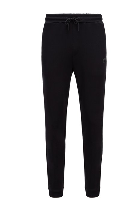 Cuffed tracksuit bottoms in cotton with tonal piqué structure, Black