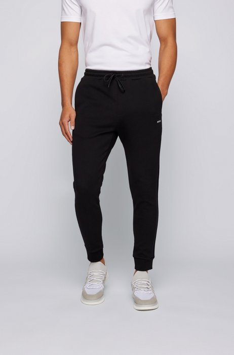 Cuffed cotton-blend tracksuit bottoms with tonal logo tape, Black