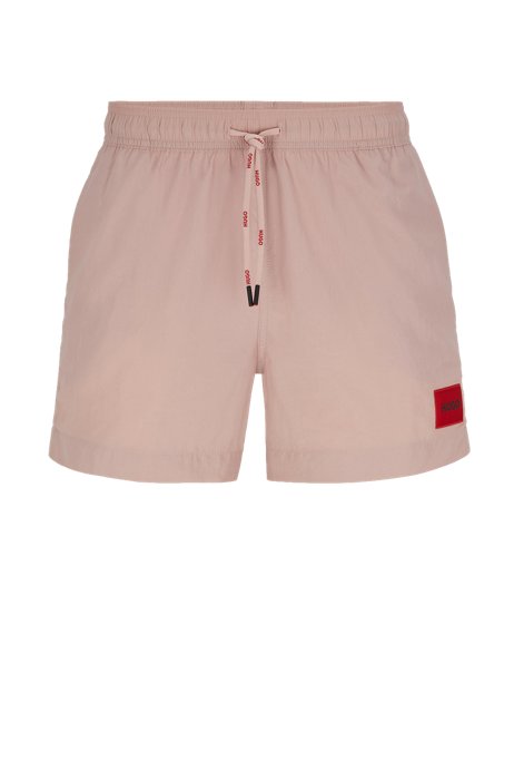 Quick-drying swim shorts with red logo label, light pink