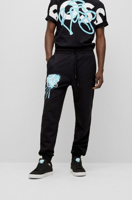 Relaxed-fit tracksuit bottoms with graffiti artwork, Black