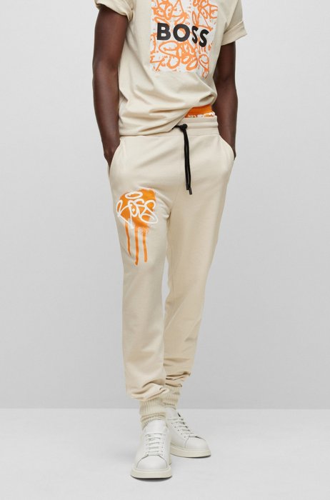 Relaxed-fit tracksuit bottoms with graffiti artwork, Light Beige