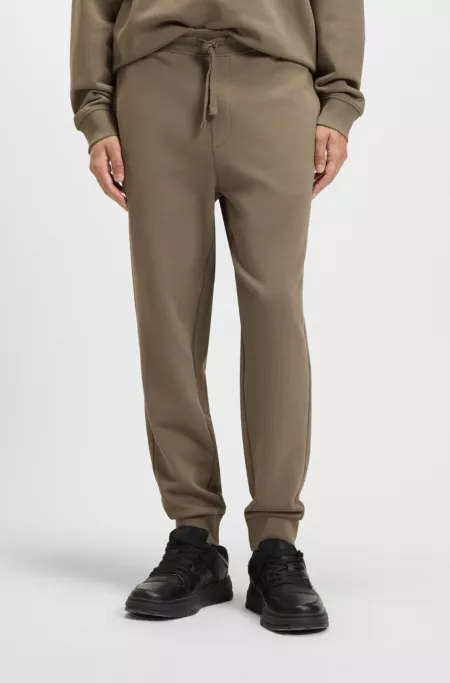 Cuffed tracksuit bottoms in cotton terry with logo print