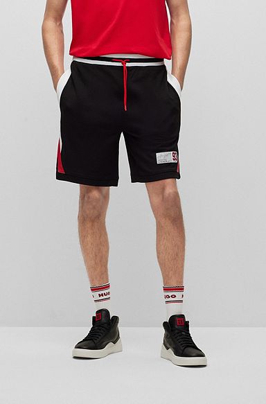 Shorts aus Mesh mit kontrastfarbenen Streifen und Web-Etikett, Schwarz
