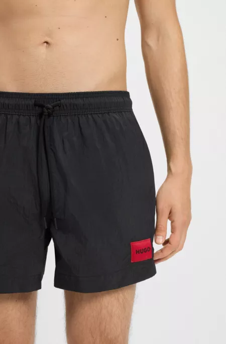 Fully lined swim shorts with red logo label