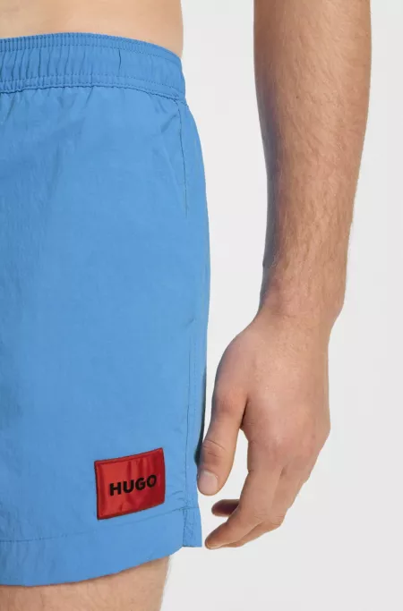 Fully lined swim shorts with red logo label