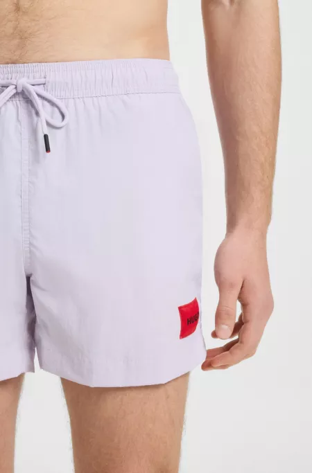 Fully lined swim shorts with red logo label