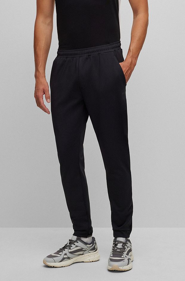 Cuffed tracksuit bottoms in active-stretch fabric, Black