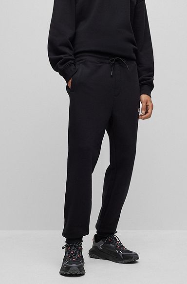 Monogram-print tracksuit bottoms with striped tape, Black