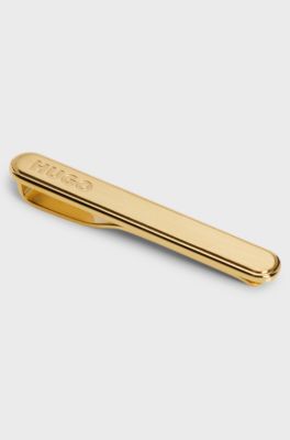 Oval-shaped tie clip with engraved logo, Gold tone