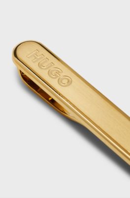 Oval-shaped tie clip with engraved logo, Gold tone