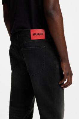 Jeans tapered fit de denim el&aacute;stico negro, Negro