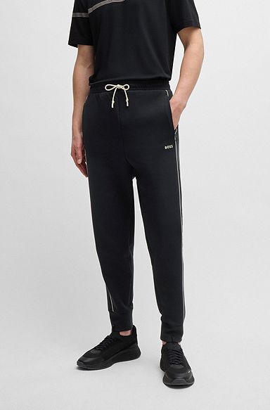 Stretch-cotton tracksuit bottoms with embossed artwork, Black