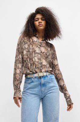 B&auml;lte i italienskt l&auml;der med en guldf&auml;rgad berlock med logga , Naturf&auml;rg