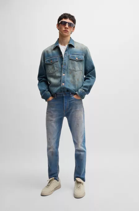 Jean Tapered en denim bleu à délavage effet boue