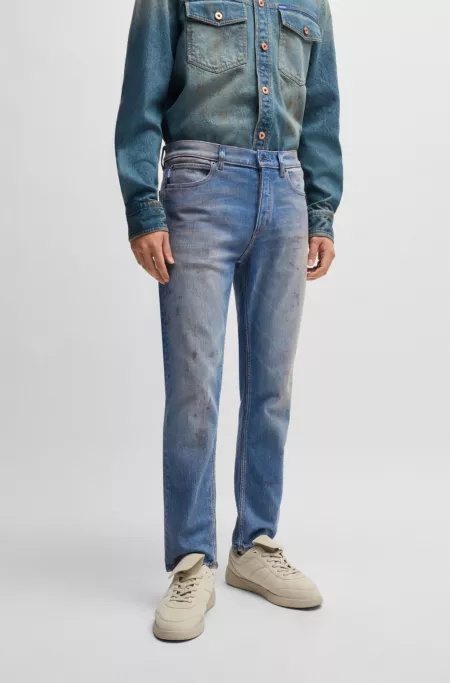 Jean Tapered en denim bleu à délavage effet boue