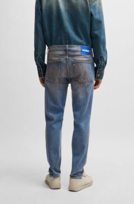 Jeans con fit affusolato in denim blu con effetto fango, Blu