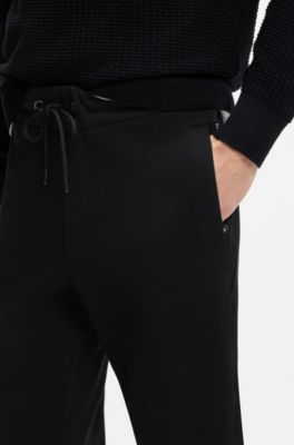 Pantalon de surv&ecirc;tement en coton stretch avec bas de jambes resserr&eacute;s, Noir