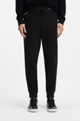 Pantalon de surv&ecirc;tement en coton stretch avec bas de jambes resserr&eacute;s, Noir