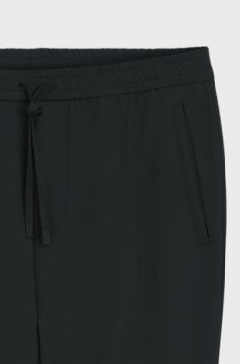Pantalon Tapered en tissu stretch d&eacute;perlant, Noir