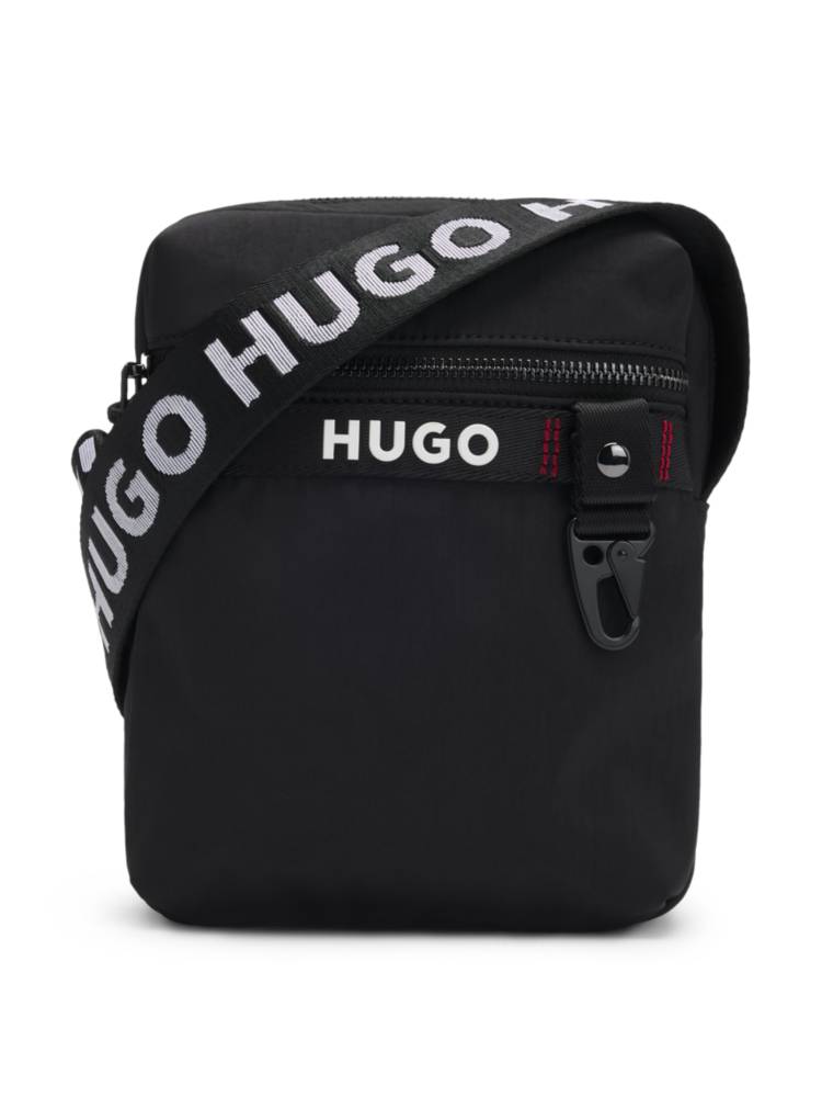 Artikel klicken und genauer betrachten! - Charakteristischer HUGO Reporter-Tasche mit kontrastierendem Logo. Das Accessoire ist mit einem verstellbaren Riemen mit HUGO Logos versehen. Die Maße: 21,0 x 16,5 x 7,0 Zentimeter. | im Online Shop kaufen