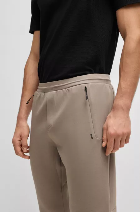 Stretch tracksuit bottoms with laser-cut holes