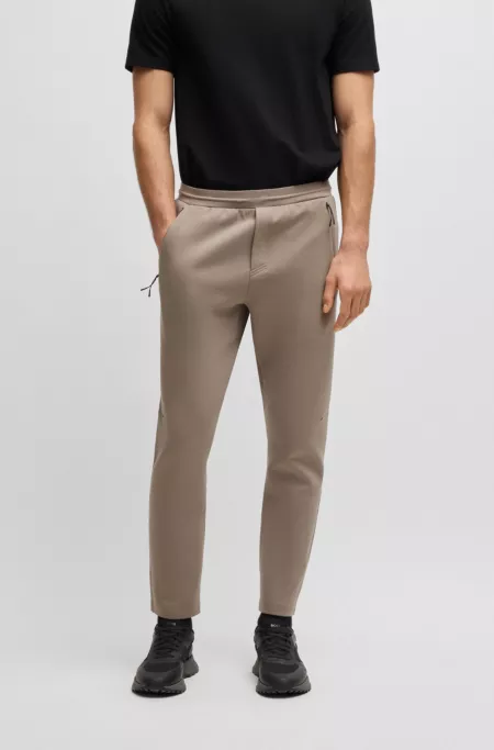 Stretch tracksuit bottoms with laser-cut holes