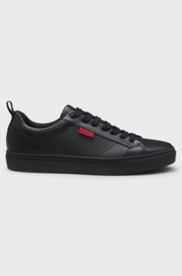 Sneakers van imitatieleer met rode logovlag, Zwart