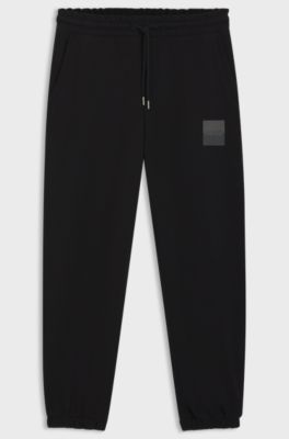 Cotton-terry tracksuit bottoms with split logo, Black