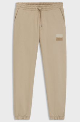 Cotton-terry tracksuit bottoms with split logo, Beige