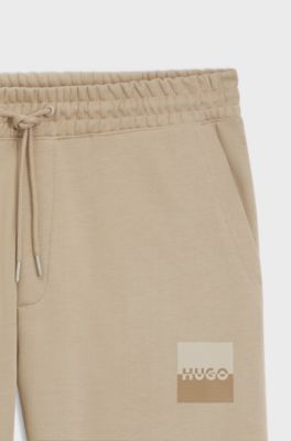 Cotton-terry tracksuit bottoms with split logo, Beige