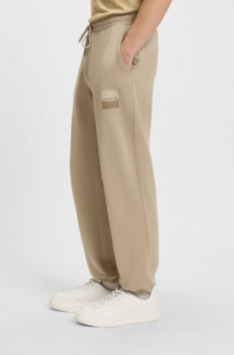 Cotton-terry tracksuit bottoms with split logo, Beige