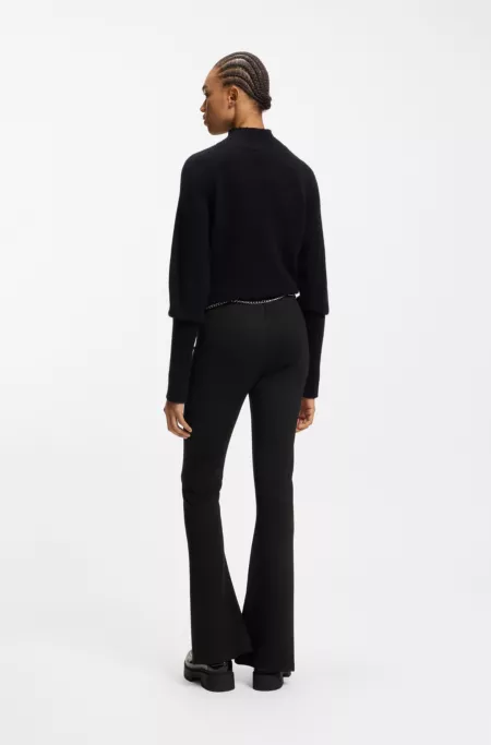 Hose mit ausgestelltem Bein, Schlitzen auf der Vorderseite und Kettengürtel