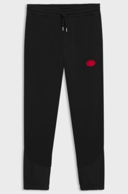 Cotton-blend tracksuit bottoms with waxed-stamp logo, Black