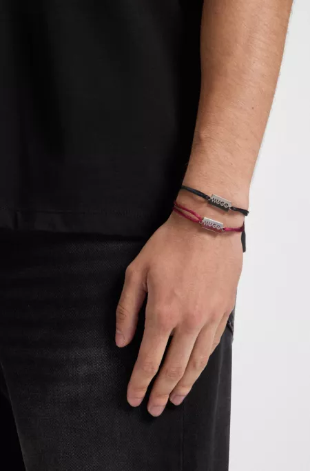 Two cord cuffs with split-logo plaques