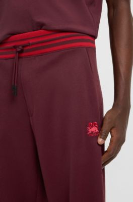 HUGO x RB oversized-fit tracksuit bottoms with striped waistband, Dark Red