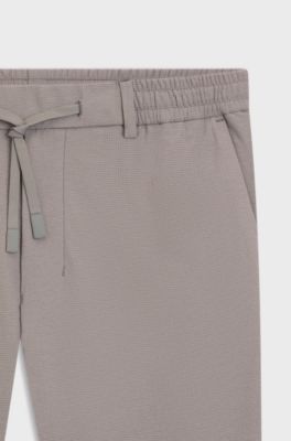 Tapered-fit trousers in waffle-structured stretch fabric, Grey